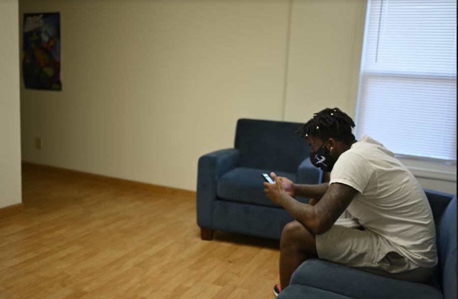 Photo of a student sitting alone in university residence. Photo by Robert Purchase II.
